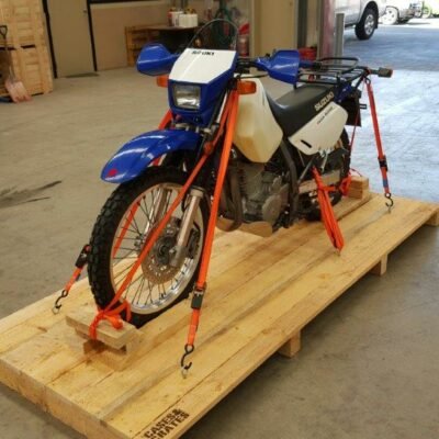 Suzuki dirt bike strapped on a wooden pallet