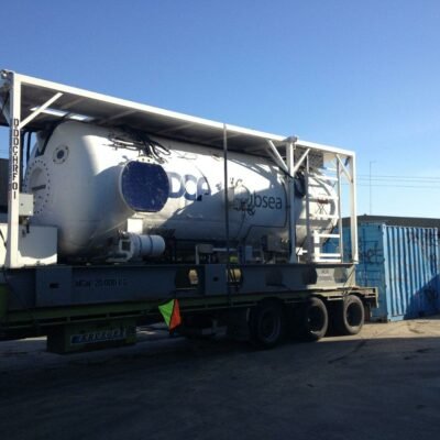 Cylindrical industrial tank mounted on a low-loader trailer