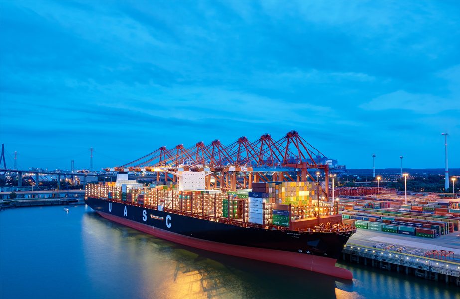 Container ship loading at port at dusk